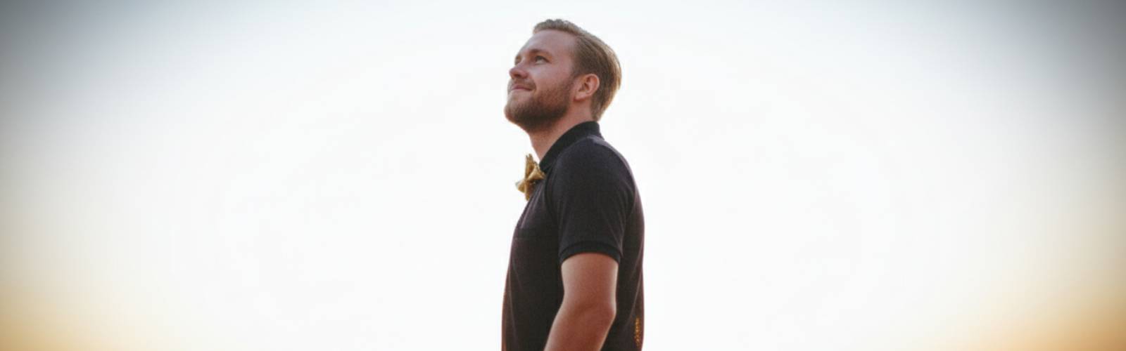 Mann schaut optimistisch nach oben mit leichtem Lächeln.