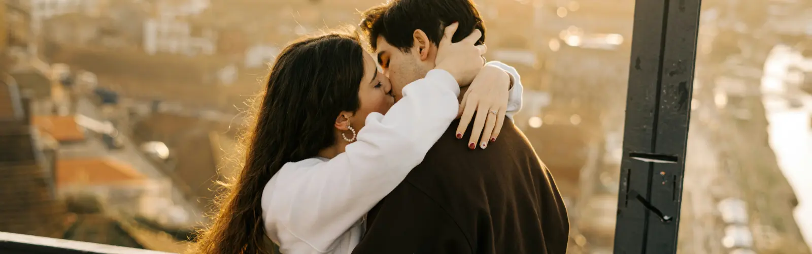 Glückliches Paar küsst sich bei Sonnenuntergang nach einem Date.