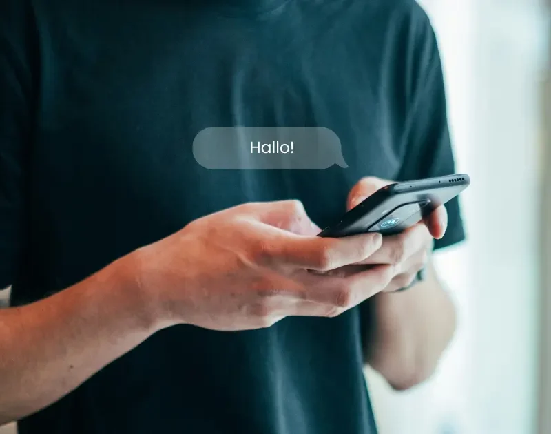 Nahaufnahme eines Mannes, der eine „Hallo!“-Nachricht sendet.