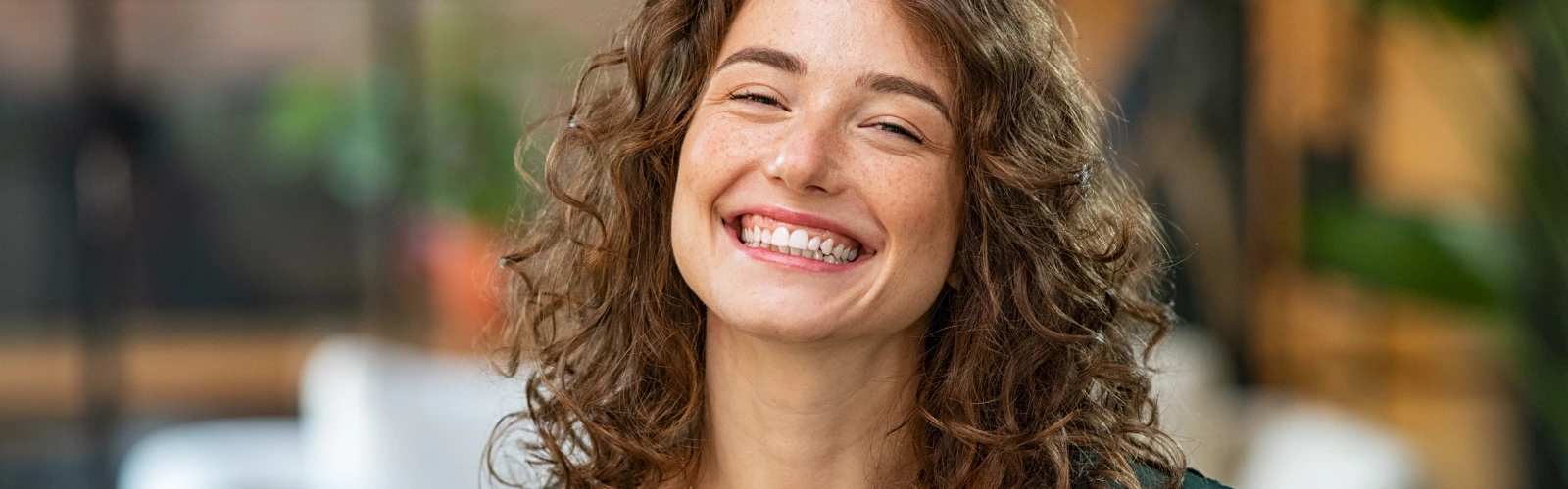 Prestigemen – Paar umarmt sich draußen und lacht gemeinsam voller Freude.