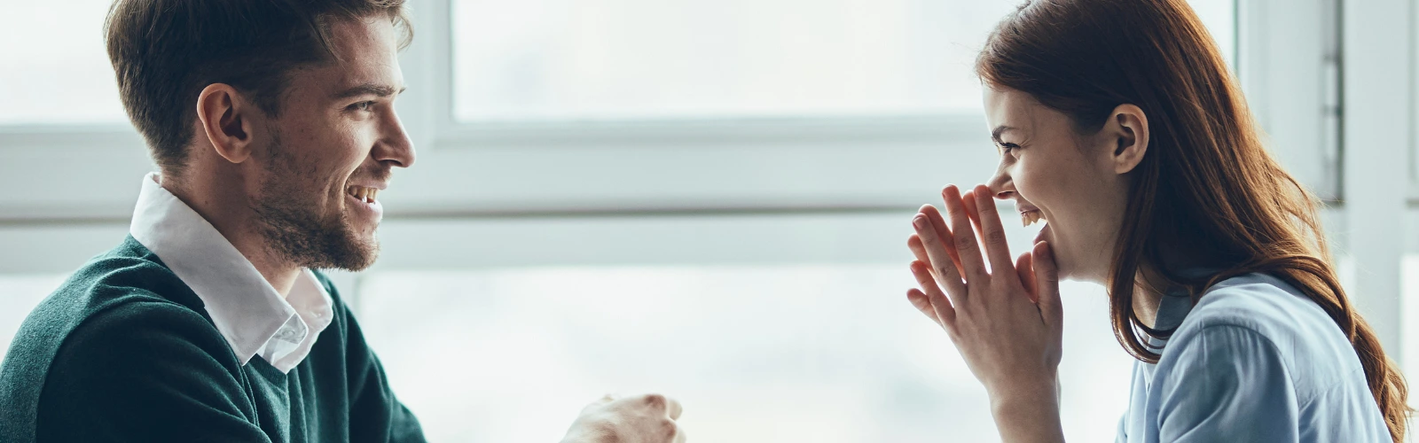 Prestigemen – Mann und Frau lachen gemeinsam, Seitenansicht.