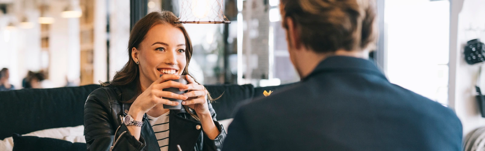 Prestigemen – Paar trinkt Kaffee, die Frau lächelt.