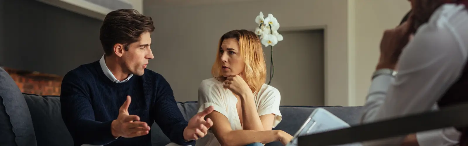 Ein ernstes Paar im Beratungsgespräch auf einem Sofa – Suche nach Lösungen und Handlungsoptionen für die Beziehung.