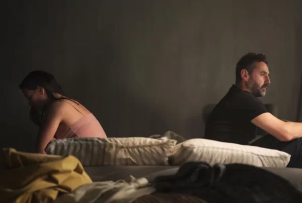 Ein unglückliches Paar sitzt distanziert auf dem Sofa und vermeidet Blickkontakt als Zeichen für Beziehungsprobleme.