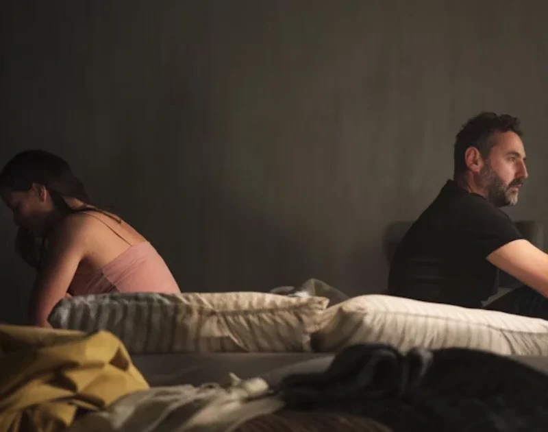 Ein unglückliches Paar sitzt distanziert auf dem Sofa und vermeidet Blickkontakt als Zeichen für Beziehungsprobleme.