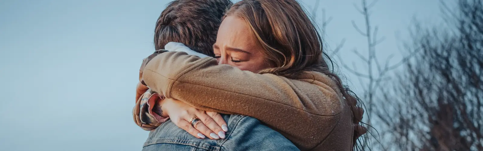 Eine Frau hält sich weinend an einen Mann geklammert, symbolisierend einen Wendepunkt in der Beziehung.