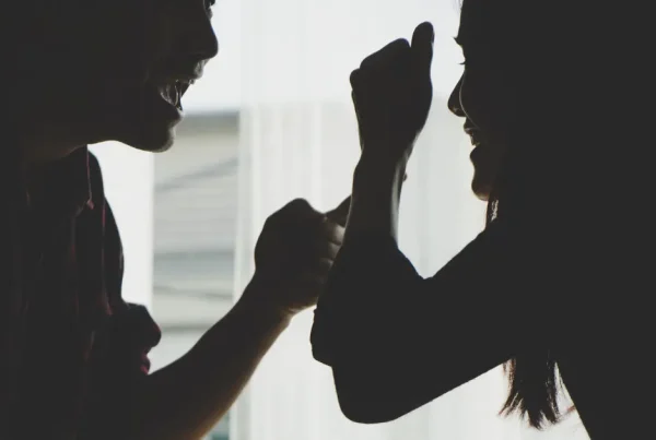 Silhouette eines Paares im Profil, das sich im Schatten heftig streitet – Symbol für Warnsignale einer kaputten Beziehung.