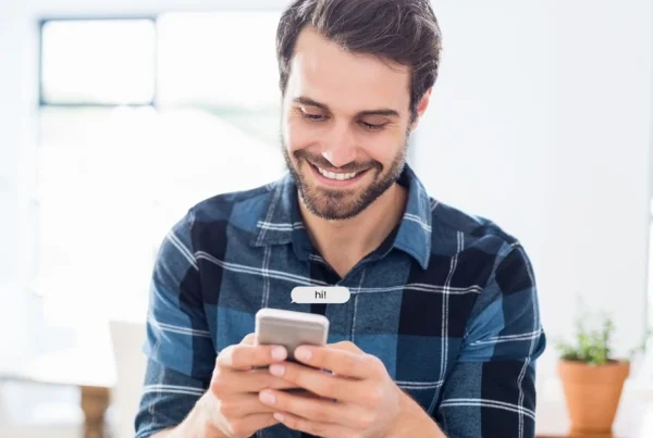 Mann lächelt beim Schreiben einer anonymen Nachricht in einem kostenlosen Chatroom ohne Anmeldung.