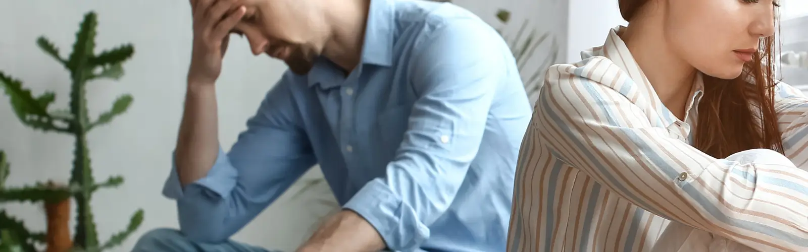 Gestresstes Paar sitzt voneinander abgewandt – mögliche Ursache von Bindungsangst in Beziehungen
